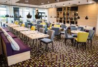 Premier Sofia Airport Hotel في صوفيا: مطعم به طاولات وكراسي في غرفة