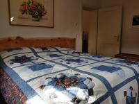 a bed with a blue and white quilt on it at Ferienappartement am Leisnitzbach in Tamsweg