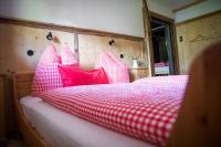 a bed with red and white pillows on it at Tradlhof in Thierbach