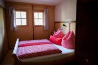 a bedroom with a bed with red and white pillows at Tradlhof in Thierbach