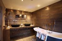 a bathroom with two sinks and a bath tub at Hotel Le Saint Roch in Courchevel