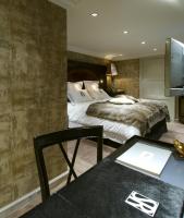 a hotel room with a bed and a desk with a table at Hotel Le Saint Roch in Courchevel