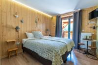 a bedroom with a bed and wooden walls at Domaine du Hirtz, Restaurant &amp; Spa in Wattwiller