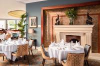 comedor con mesas y chimenea en The Culloden Estate and Spa, en Belfast