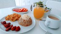 a table with a plate of food and a cup of coffee at Akuamarina Hotel in Santa Marta