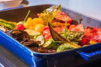 斯塔里斯I Resort Beach Hotel & Spa的桌子上放着一个装满蔬菜的蓝色平底锅。