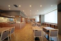 盛岡市にあるドーミーイン盛岡の木製のテーブルと椅子、バーのあるレストラン