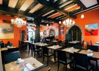 a dining room with tables and chairs and chandeliers at Le B. VINTAGE in Riquewihr