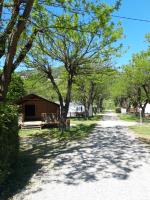 a dirt road with a building and trees at Camping La Bohème in Tournon-sur-Rhône