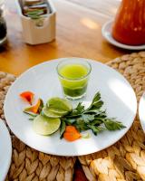 a white plate with a glass of green juice at Encuentro Guadalupe in Valle de Guadalupe