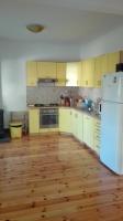 a kitchen with yellow cabinets and a white refrigerator at Villa Nadija in Čanj