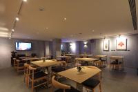 Un restaurante con mesas y sillas y un televisor de pantalla plana. en Water House, en Taipéi