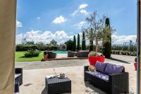 a patio with a couch and chairs and a pool at Mas Saint Julien in Cavaillon