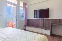 a bedroom with a bed and a flat screen tv at Kenting Maya-House B&amp;B in Kenting