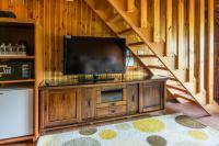 a flat screen tv on a wooden entertainment center in a cabin at Kenting Maya-House B&amp;B in Kenting
