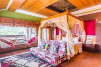 a bedroom with a canopy bed and a couch at Kenting Maya-House B&amp;B in Kenting