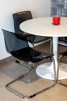 ein weißer Tisch mit zwei schwarzen Stühlen um ihn herum in der Unterkunft studio du botanique in Bayeux