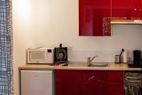 eine Küche mit Mikrowelle und Spüle in der Unterkunft studio du botanique in Bayeux