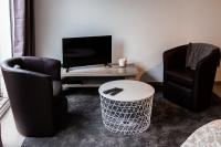 ein Wohnzimmer mit 2 Stühlen und einem Tisch in der Unterkunft studio du botanique in Bayeux
