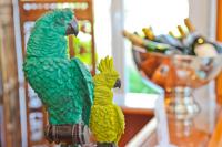 two green parrots sitting on a pole on a table at Hôtel La Villa Cap d’Antibes in Juan-les-Pins