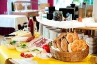 una mesa con una cesta de pan y otros alimentos en Hotel St. Virgil Salzburg, en Salzburgo