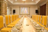 une longue table avec des chaises jaunes et de la vaisselle dessus dans l'établissement Khách sạn Hậu Giang, à Vị Thanh