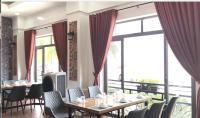 une salle à manger avec tables et chaises et de grandes fenêtres dans l'établissement Khách sạn Hậu Giang, à Vị Thanh