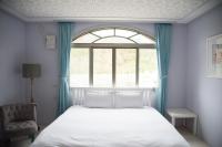 a bedroom with a white bed and a window at Green 58 B&amp;B in Hengchun South Gate