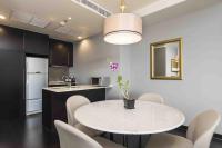 a kitchen and dining room with a white table and chairs at Chatrium Hotel Riverside Bangkok in Bangkok