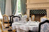 a dining room with a table and chairs and a fireplace at Alexandra Palace - La Maison Younan in Mazières-en-Gâtine