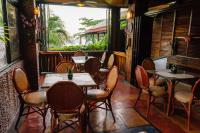 een restaurant met tafels en stoelen en een raam bij Hayahay Resort in Panglao