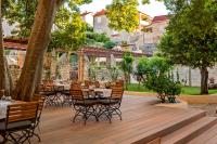 普契什查Puteus Palace Heritage Hotel的木甲板上设有桌椅的餐厅