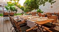 普契什查Puteus Palace Heritage Hotel的户外用餐区设有木桌和椅子