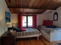 a bedroom with a bed and a window with red curtains at Caseddu Di Poggiale in Figari