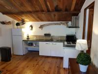 a kitchen with white appliances and a wooden ceiling at Caseddu Di Poggiale in Figari