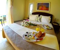 a breakfast tray with eggs and bread on a bed at PLEIADES lUXURY APARTMENTS in Porto Heli