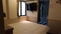 a room with a bed and a tv and a shower at Galaxy Mini Inn in Taipei