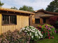 a wooden house with flowers in front of it at Salamandre et Hippocampe in Lanton