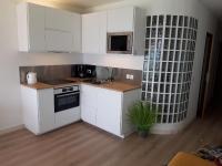 a kitchen with white cabinets and a sink and a microwave at Antibes: A nest perched on the sea! in Antibes