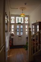 a hallway with a white door and stained glass windows at Gatwick Castle B&B in Horley