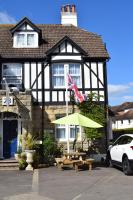 a house with a picnic table and an umbrella at Gatwick Castle B&B in Horley