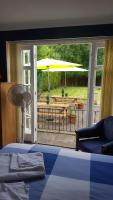 a bedroom with a bed and a patio with an umbrella at Gatwick Castle B&B in Horley