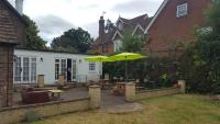 a patio with a table and an umbrella at Gatwick Castle B&B in Horley