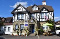 a black and white house with an umbrella in front of it at Gatwick Castle B&B in Horley