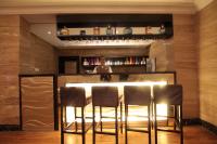 a bar in a hotel room with three stools at Boudl Kuwait Al Fahahil in Kuwait