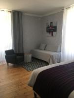 a bedroom with a bed and a couch and a chair at Tilleuls et Bambous in Saint-Sauveur-dʼAunis