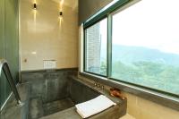 a bathroom with a shower with a sink and a window at Yang Ming Shan Tien Lai Resort &amp; Spa in Jinshan