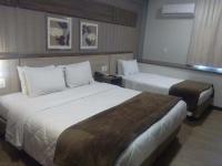 a hotel room with two beds and a window at Klein Ville São Leopoldo in São Leopoldo