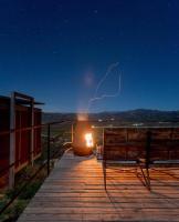 a person sitting on a boardwalk with a lightning bolt in the sky at Encuentro Guadalupe in Valle de Guadalupe