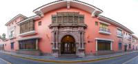 a pink building with an archway on a street at DM Hoteles Ayacucho in Ayacucho